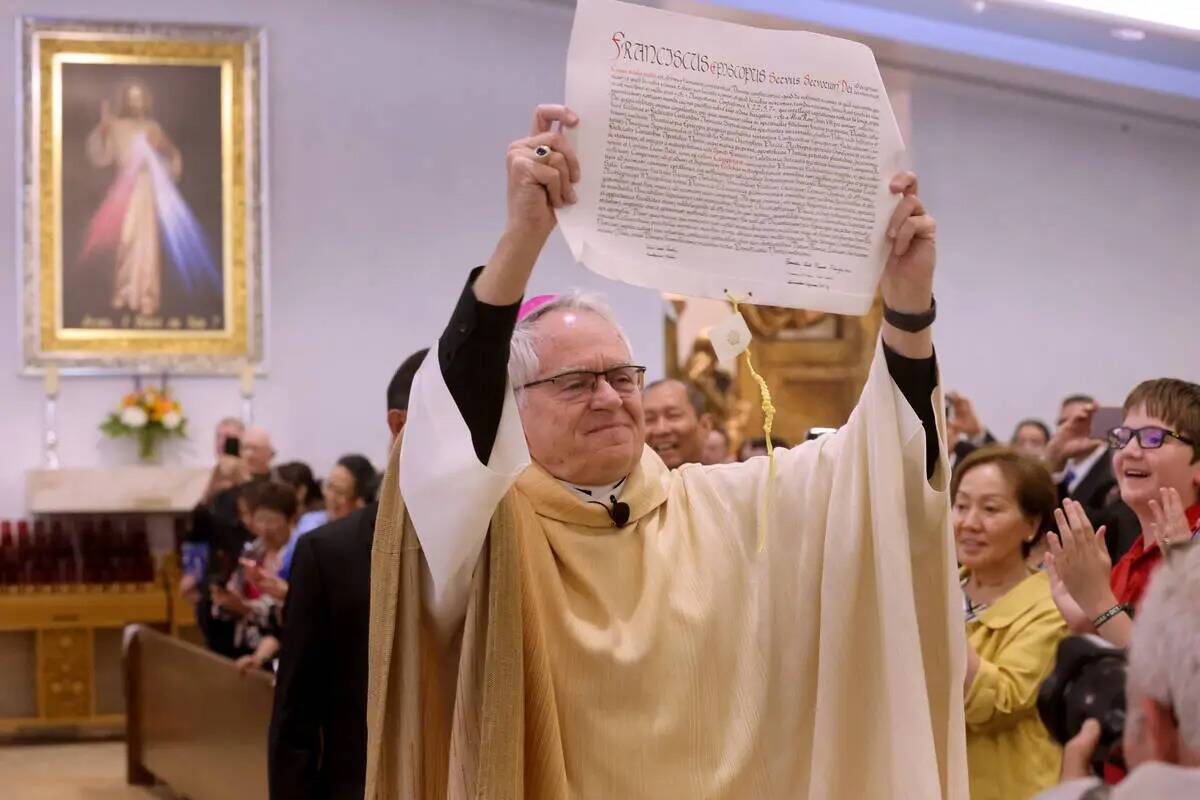 El arzobispo George Leo Thomas sostiene la bula papal que acababa de leer el cardenal Christoph ...