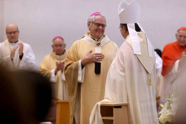 El arzobispo George Leo Thomas, a la izquierda, recibe el palio de manos del nuncio apostólico ...
