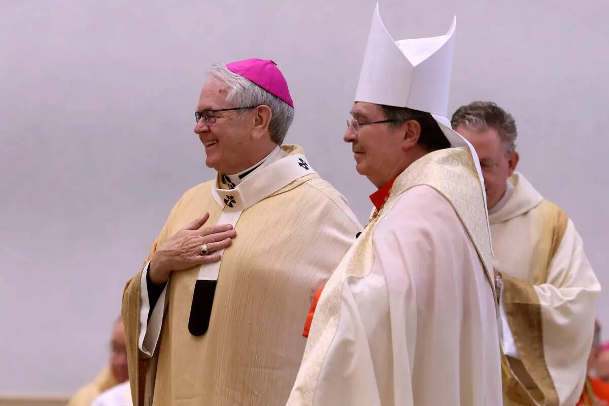 El arzobispo George Leo Thomas, a la izquierda, recibe el palio de manos del nuncio apostólico ...