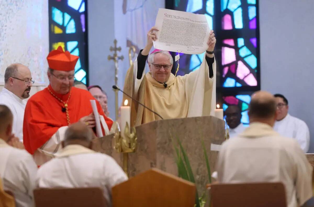 El arzobispo George Leo Thomas sostiene la bula papal que acababa de leer el nuncio apostólico ...