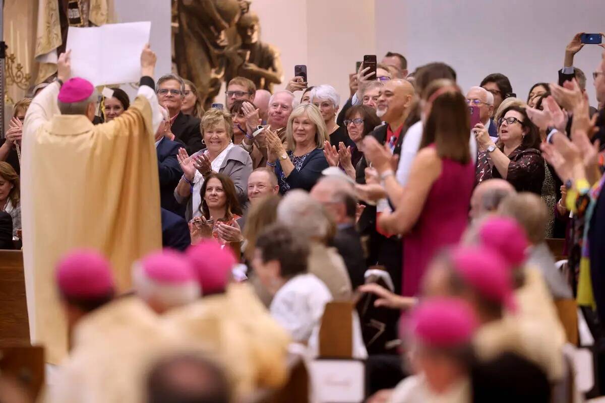 El arzobispo George Leo Thomas sostiene la bula papal que acababa de leer el nuncio apostólico ...