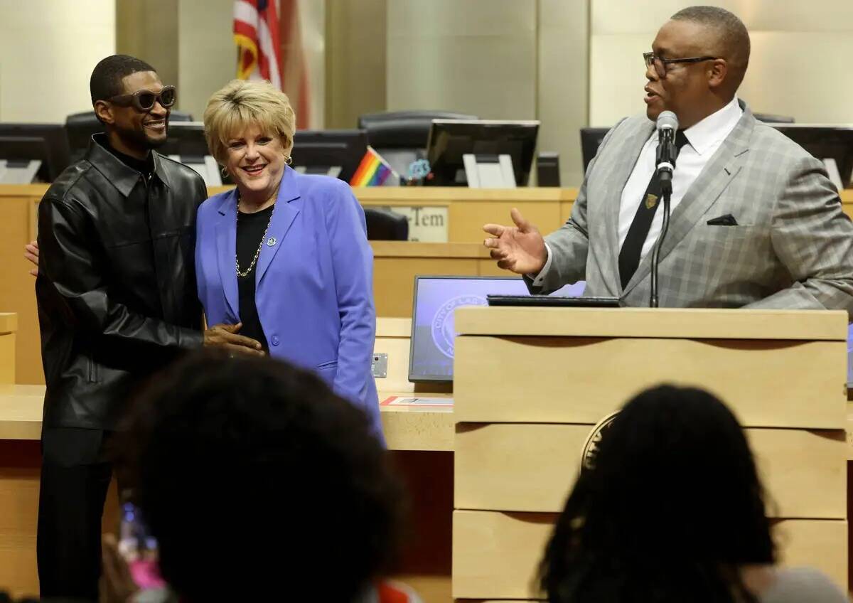Usher, a la izquierda, abraza a la alcaldesa de Las Vegas Carolyn Goodman mientras el concejal ...