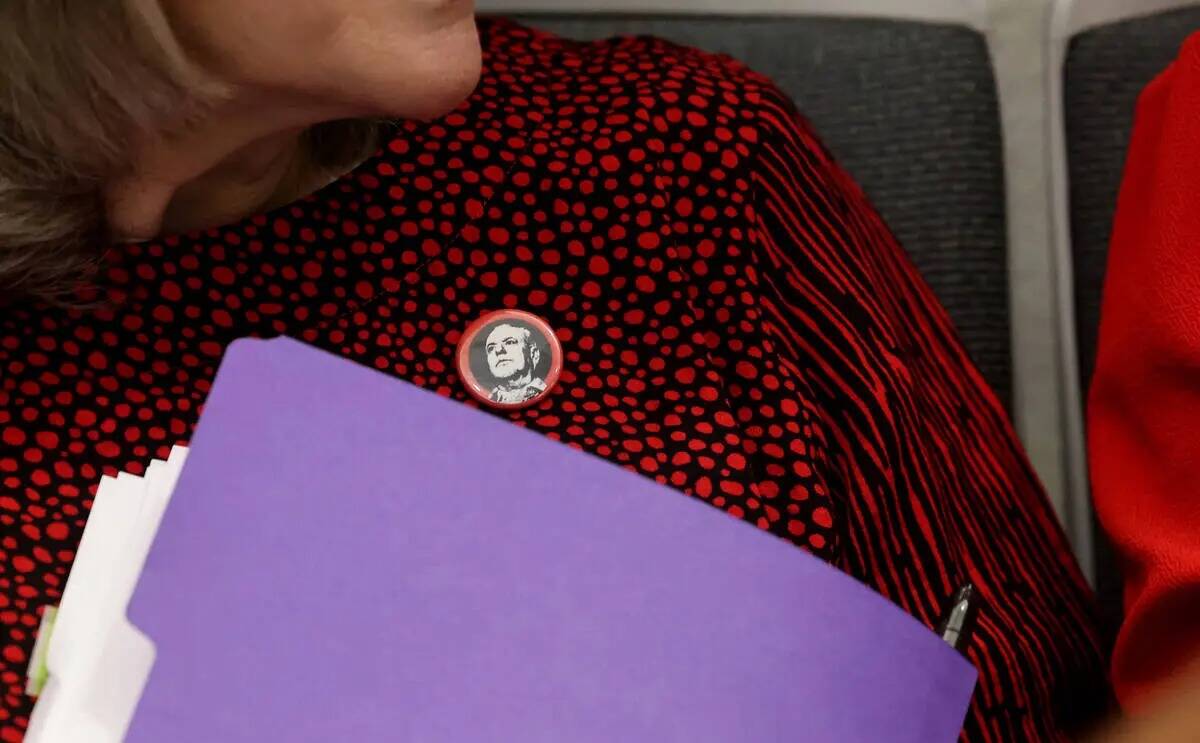 La administradora pública del Condado Clark, Rita Reid, se pone un botón con una foto del rep ...