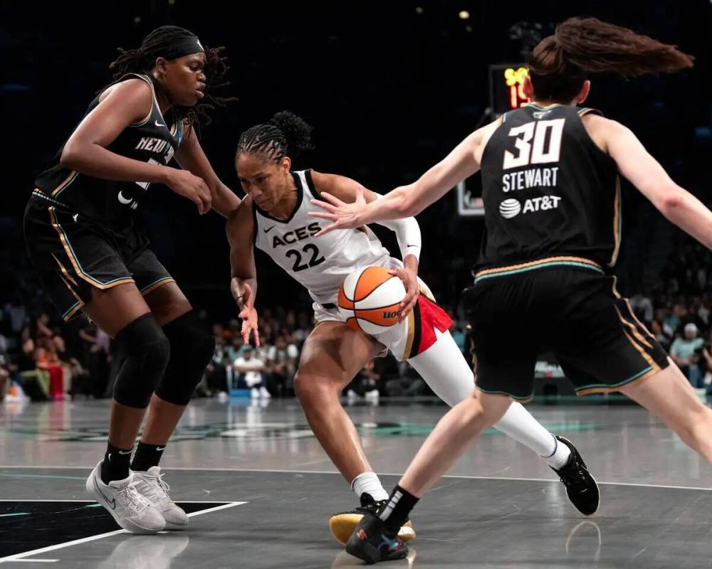 La alera de Las Vegas Aces A'ja Wilson (22) driblea entre la alera de New York Liberty Jonquel ...