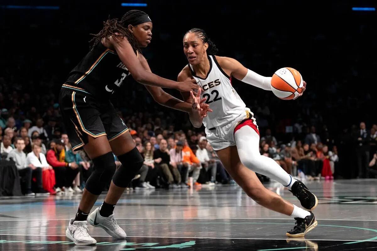 La alera de Las Vegas Aces A'ja Wilson (22) conduce alrededor de la alera de New York Liberty J ...