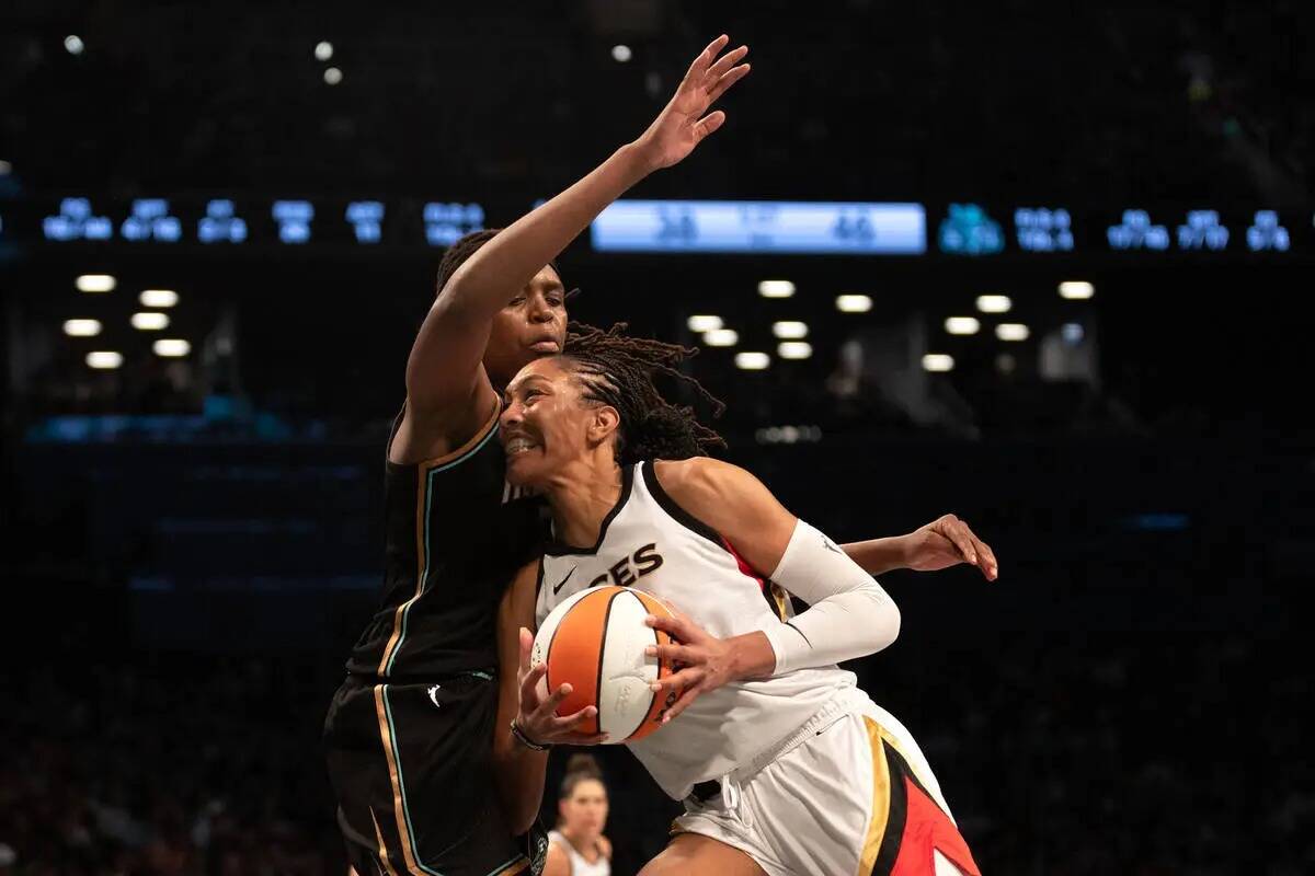 La alera de Las Vegas Aces A'ja Wilson (22) supera la defensa de la alera de New York Liberty J ...