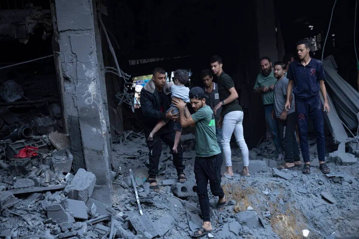 Palestinos evacuan heridos de un edificio destruido en un bombardeo israelí en Khan Younis, Fr ...