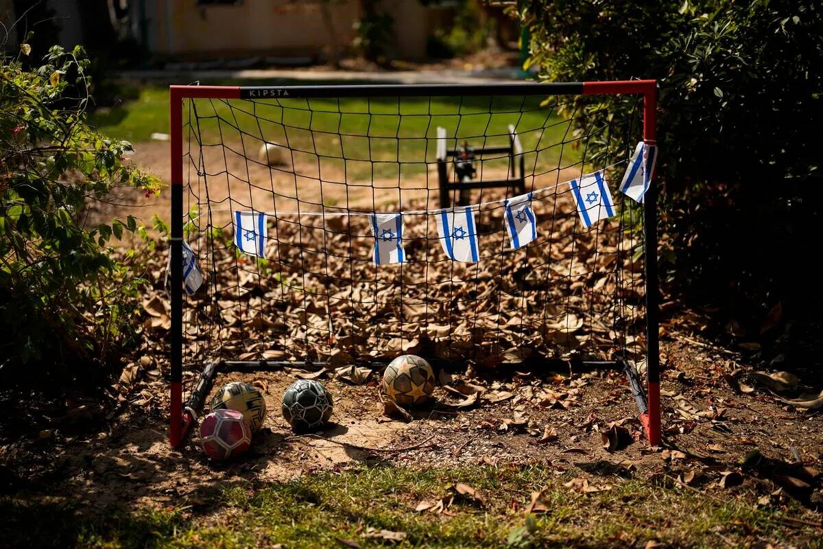 Banderas de Israel cuelgan de una portería de fútbol en el patio trasero de una casa que fue ...