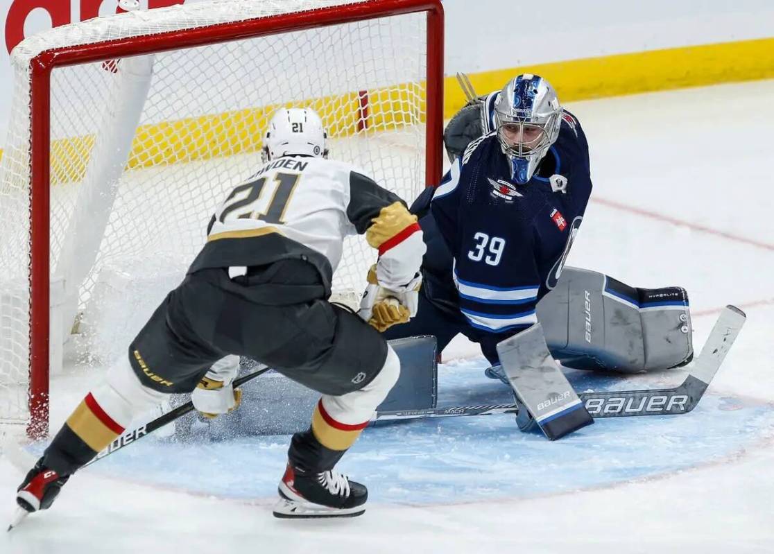 Brett Howden (21) de Vegas Golden Knights anota contra el portero de Winnipeg Jets Laurent Bros ...