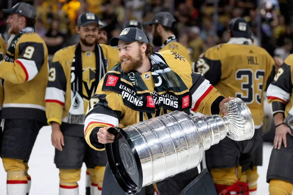 El portero de los Golden Knights Laurent Brossoit (39) celebra con la Copa Stanley después de ...