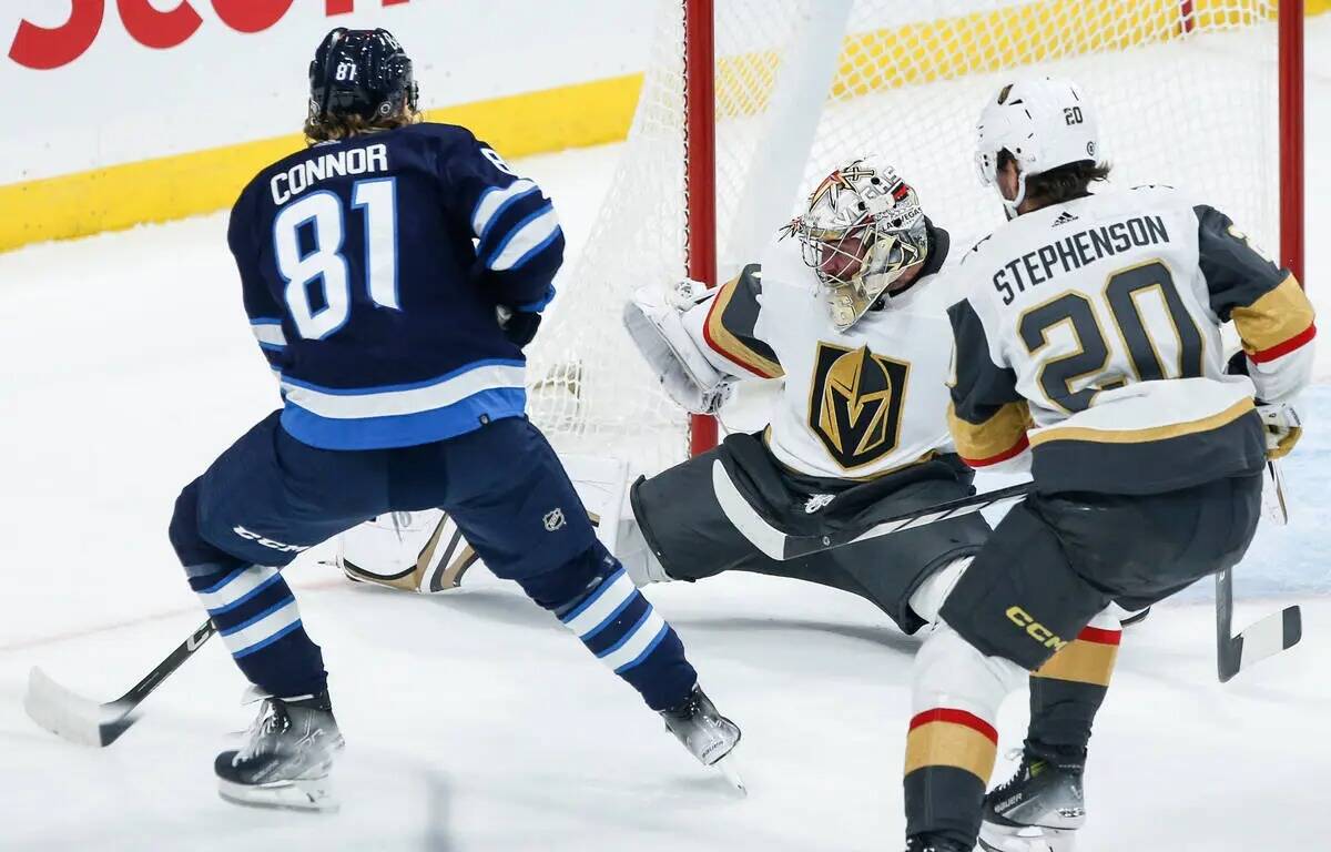 El portero de los Vegas Golden Knights, Logan Thompson, centro, ataja el disparo de Kyle Connor ...