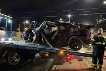 Lo que queda del Dodge Challenger de Gary Dean Robinson es subido en la plataforma de un camió ...