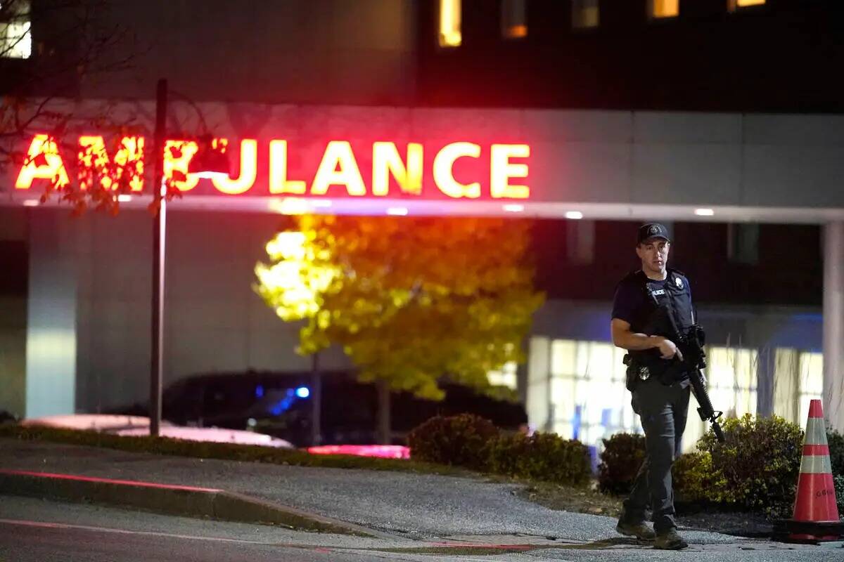 Un agente de la ley lleva un rifle fuera de Central Maine Medical Center durante una situación ...