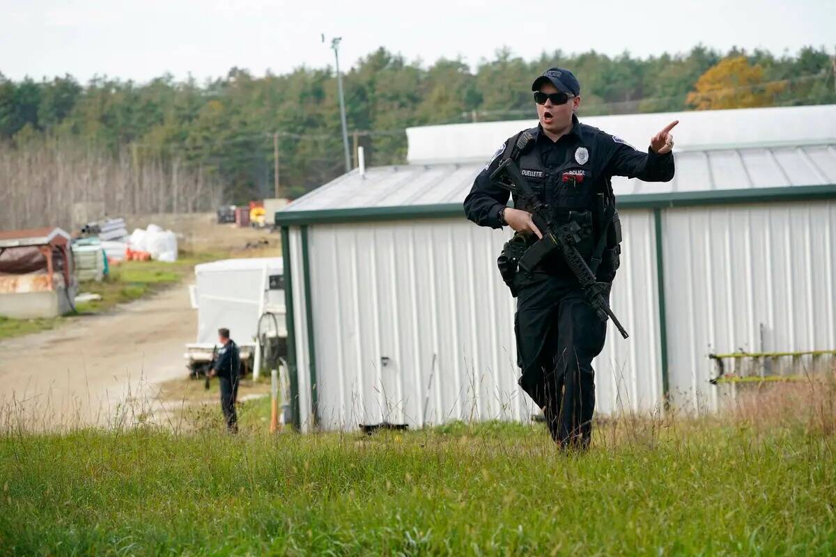 Un agente de policía da una orden al público durante una cacería humana en una granja para e ...