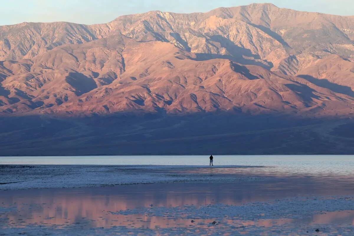Un visitante observa un extraño lago en Badwater Basin, en el recientemente reabierto Death Va ...