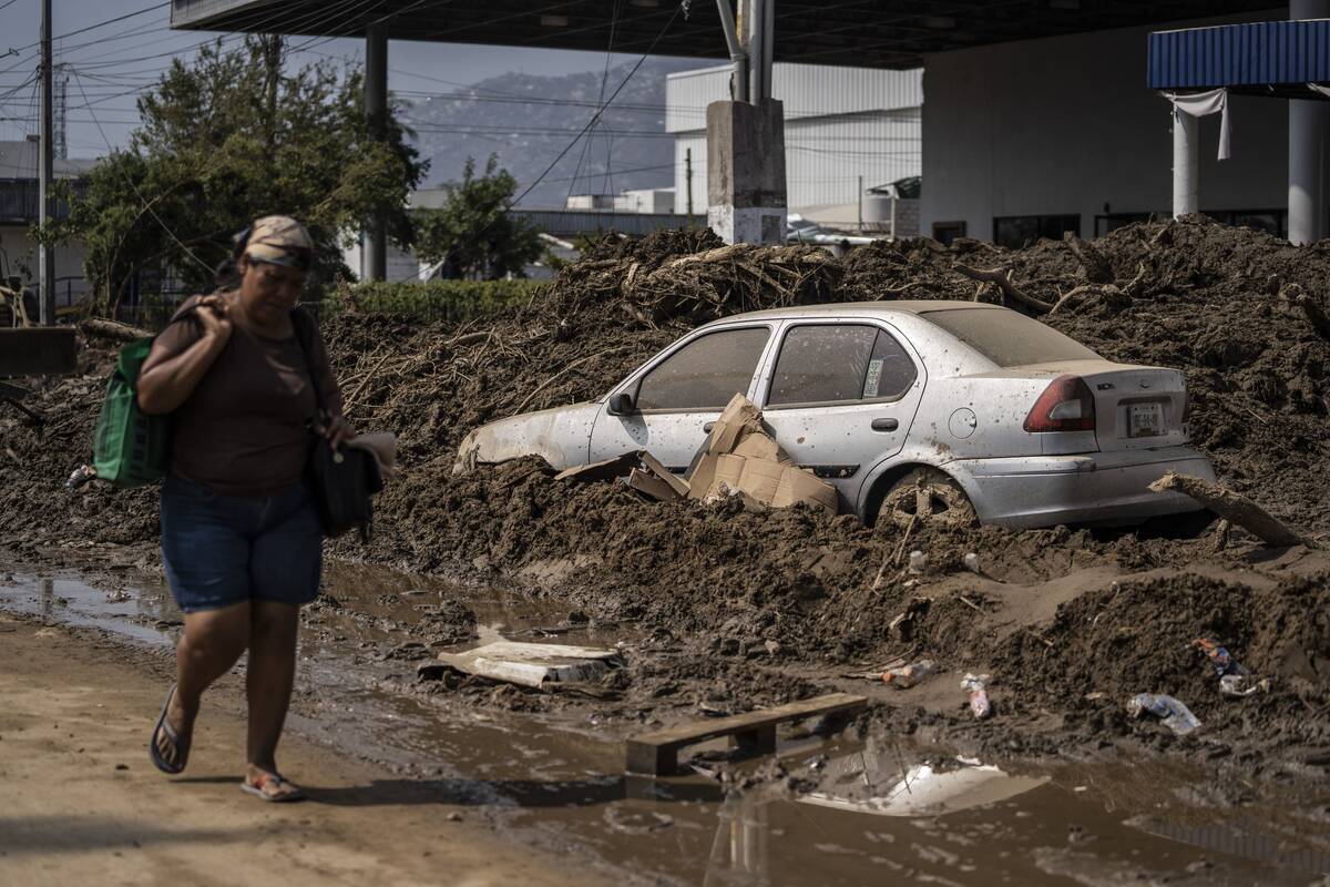 Una mujer camina por una zona dañada tras el paso del huracán Otis en Acapulco, México, el d ...