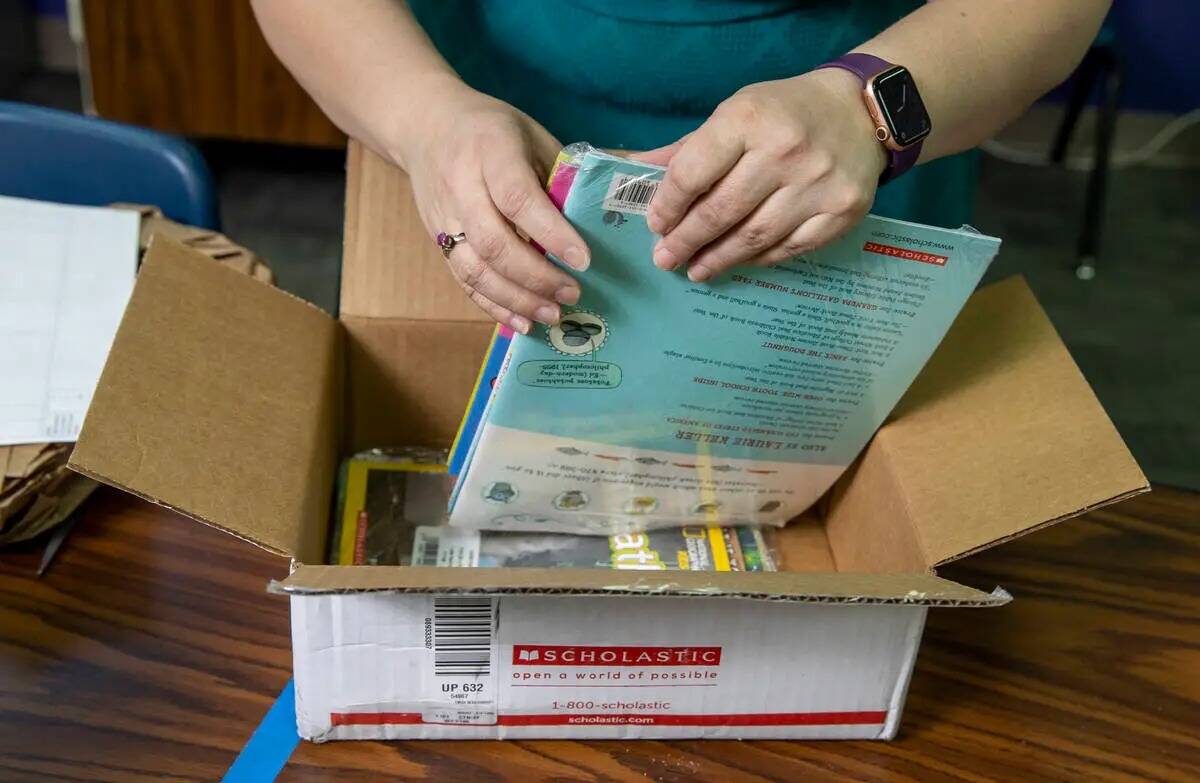 La maestra de Long STEAM Academy, Shana Prue, desempaqueta cajas de material escolar, incluidos ...