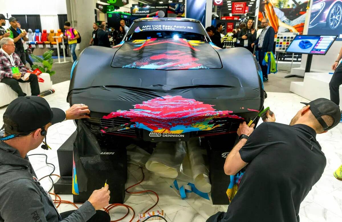 Un equipo de Avery Dennison aplica una envoltura a un Corvette durante el primer día de SEMA e ...