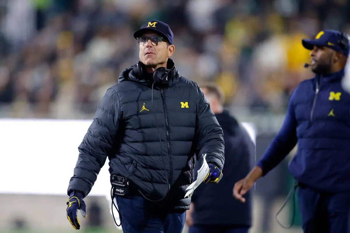 El entrenador de Michigan, Jim Harbaugh, observa durante un partido de fútbol americano univer ...