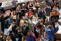 La gente espera su equipaje en un carrusel de equipaje en el Aeropuerto Internacional Harry Rei ...