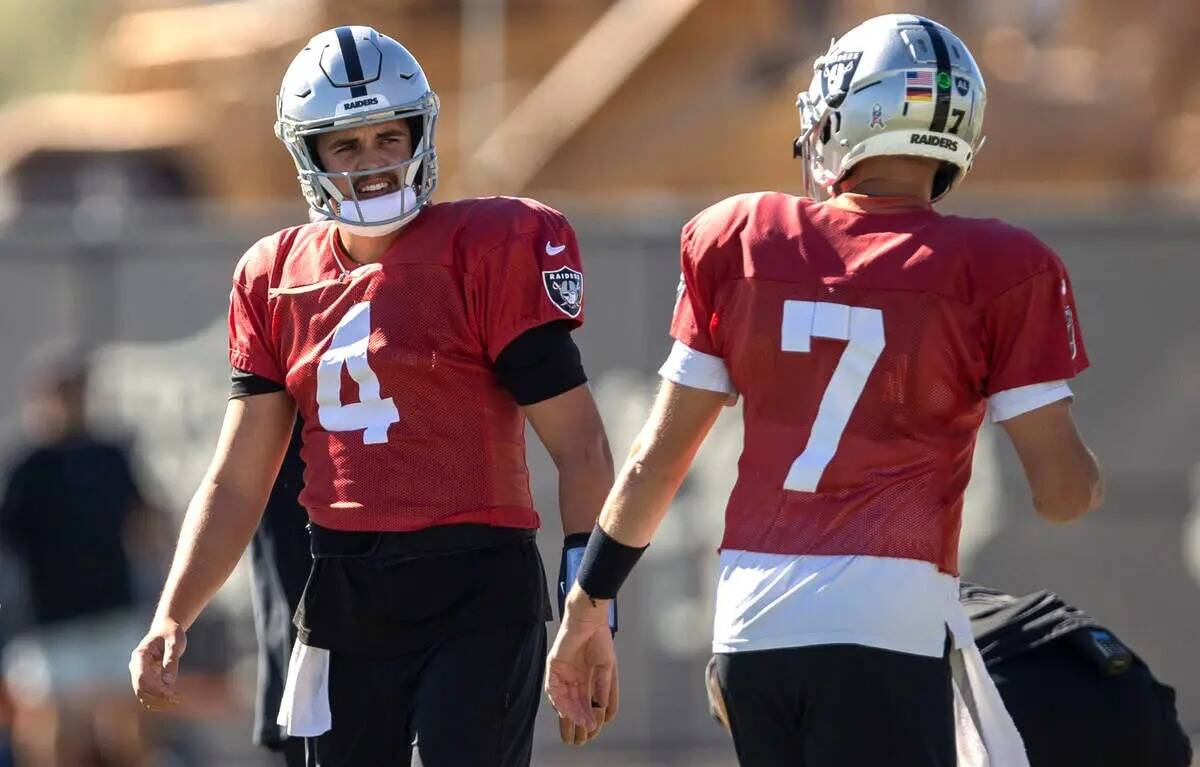 El quarterback de los Raiders Aidan O'Connell (4) y el quarterback Brian Hoyer (7) calientan du ...