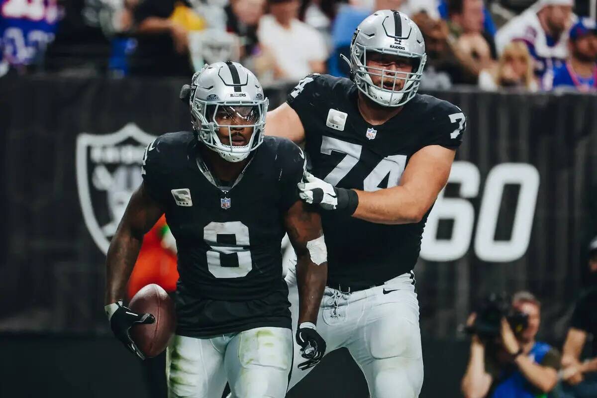 El running back de los Raiders Josh Jacobs (8) y la tacleada ofensiva Kolton Miller (74) celebr ...