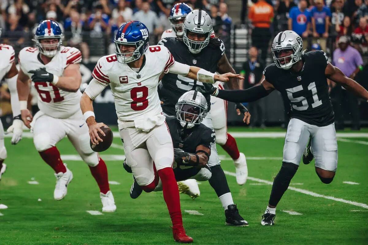 El quarterback de los New York Giants Daniel Jones (8) corre el balón mientras el cornerback d ...