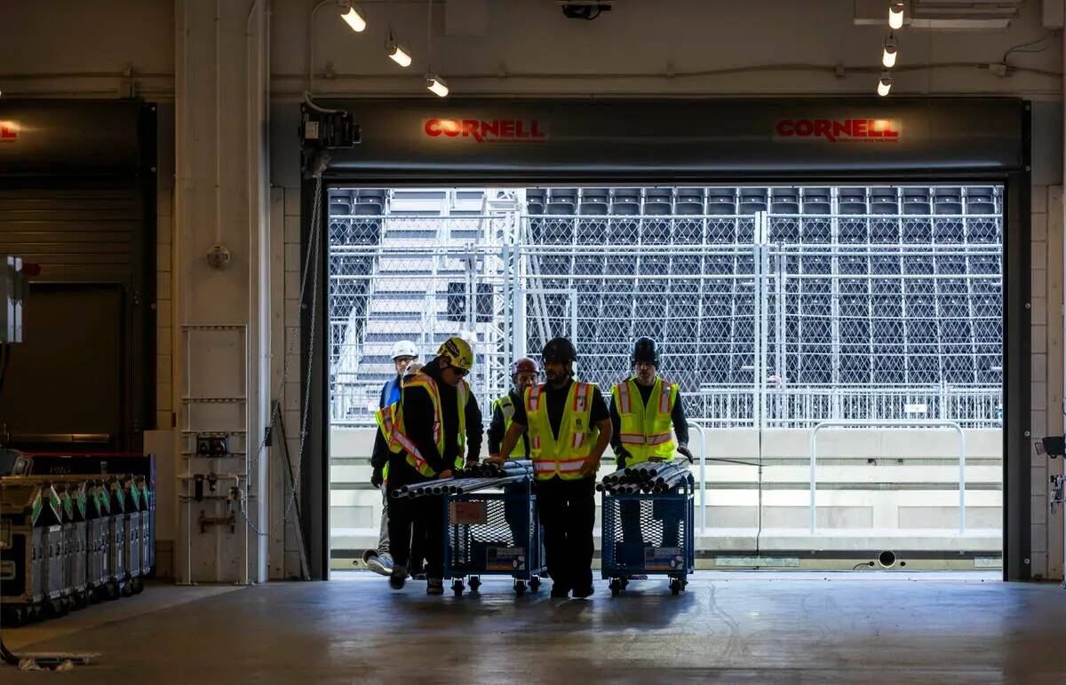 Un equipo de construcción mueve materiales a través de un garaje de equipo dentro del edifici ...