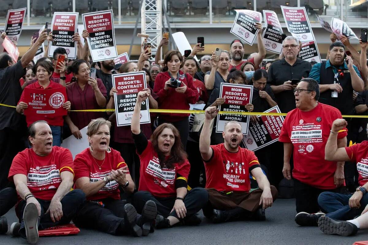 Miembros del sindicato de la culinaria se sientan en medio de Las Vegas Boulevard, bloqueando e ...
