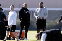 El entrenador en jefe de los Raiders, Antonio Pierce, izquierda, observa la práctica con el co ...