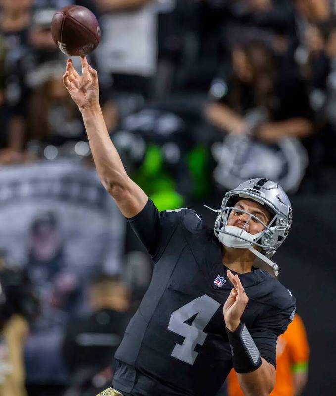 El quarterback de los Raiders Aidan O'Connell (4) lanza un pase largo durante los calentamiento ...