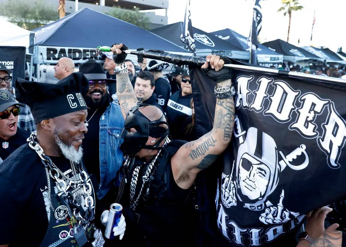 Un fan de los Raiders, Raiders-Pearl, a la derecha, ondea la bandera de los Raiders mientras ha ...