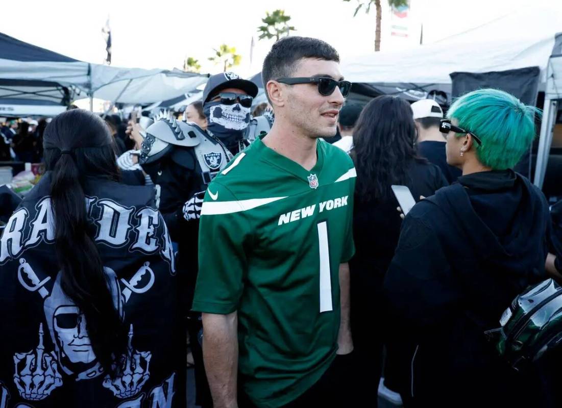 Andrew Sheehan, fan de los New York Jetts, se abre paso entre los fans de los Raiders en un tai ...