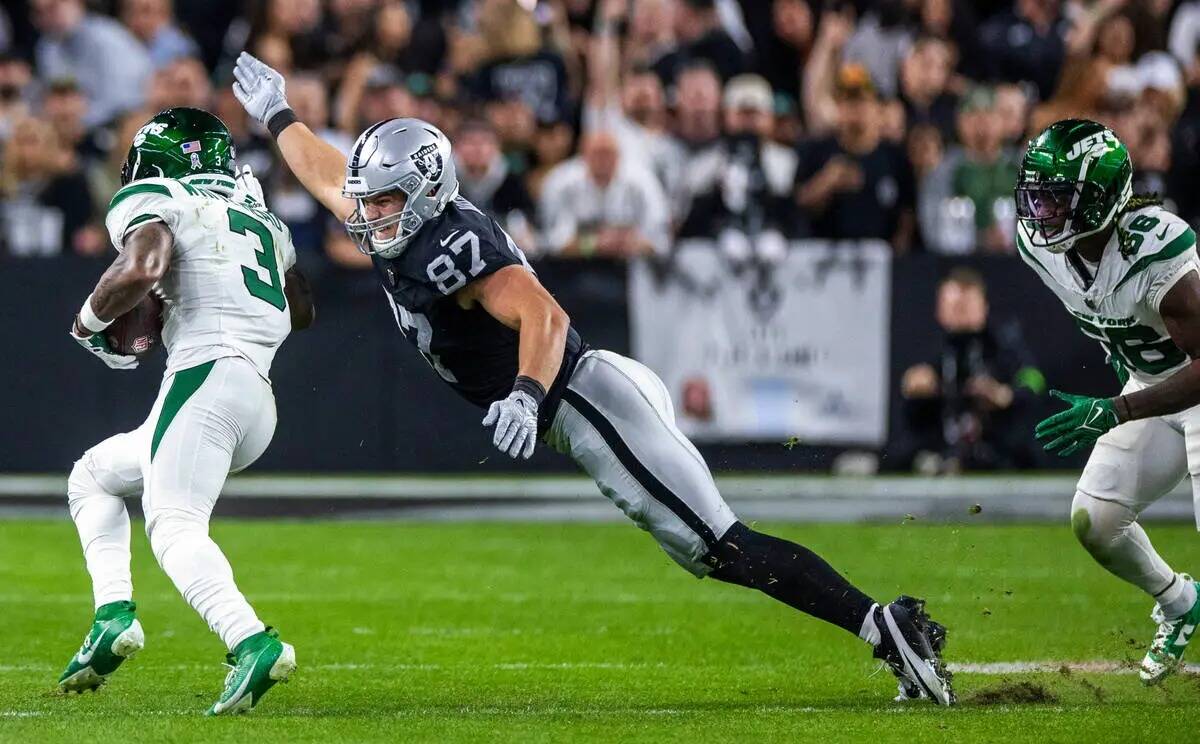 El tight end de los Raiders Michael Mayer (87) se lanza para taclear al safety de los New York ...