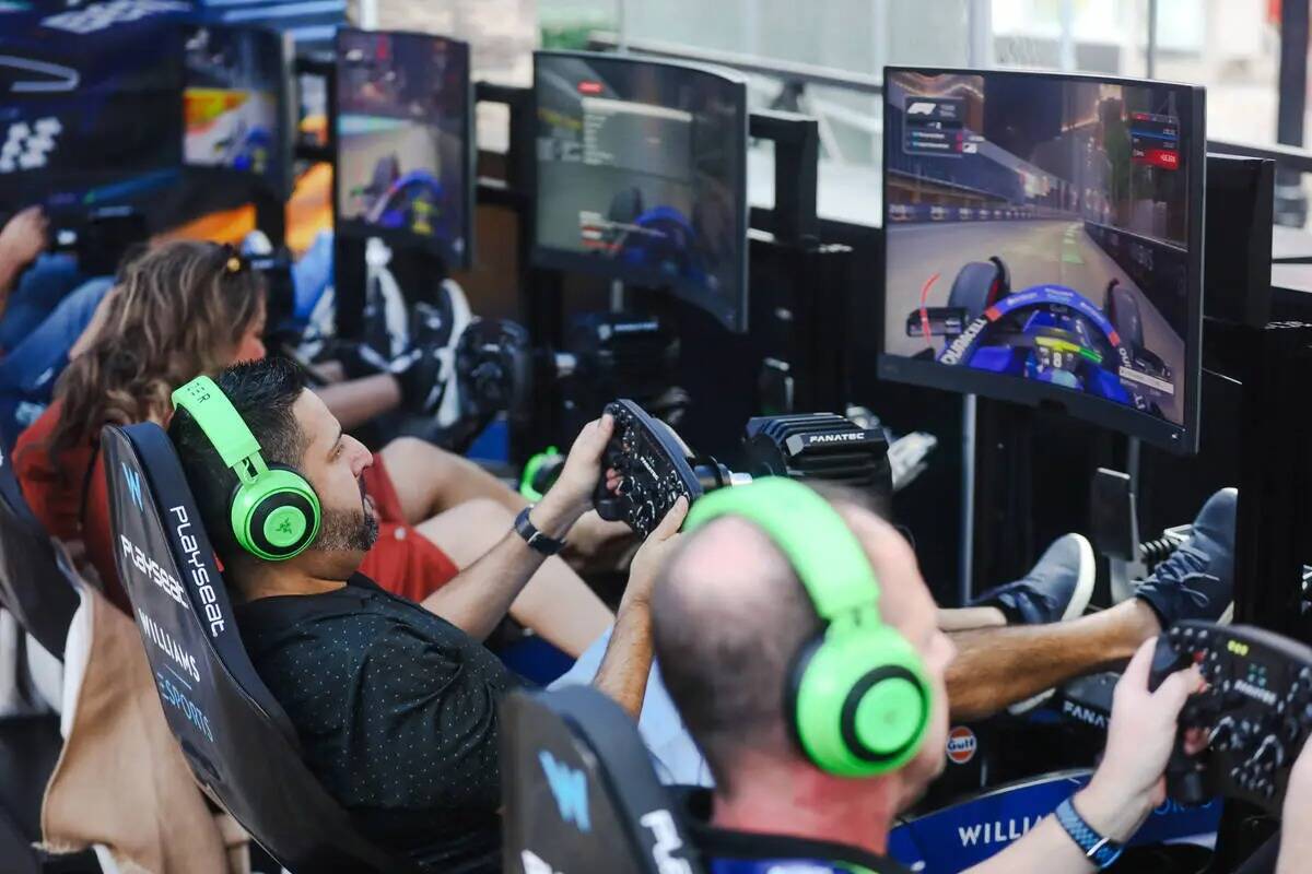 Invitados juegan a videojuegos de carreras de Fórmula Uno en el Williams Racing Fanzone, una t ...