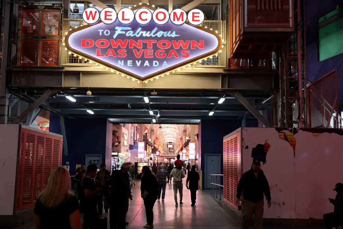 Un grupo de personas camina por Fremont Street Experience, en el centro de Las Vegas, el miérc ...