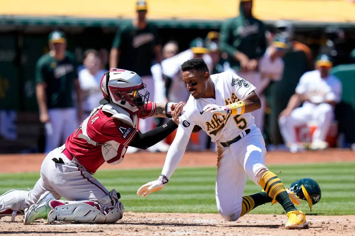 El receptor de los Diamondbacks de Arizona, José Herrera, izquierda, marca out de Tony Kemp de ...