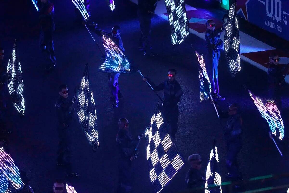 Artistas ondean banderas durante una ceremonia de apertura para la carrera de autos Fórmula Un ...