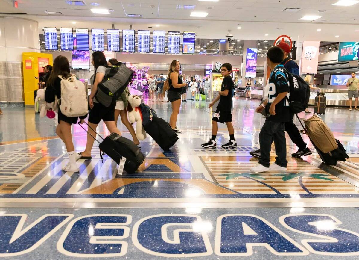 Los pasajeros que llegan se dirigen a la zona de reclamo de equipaje en la Terminal 1 del Aerop ...