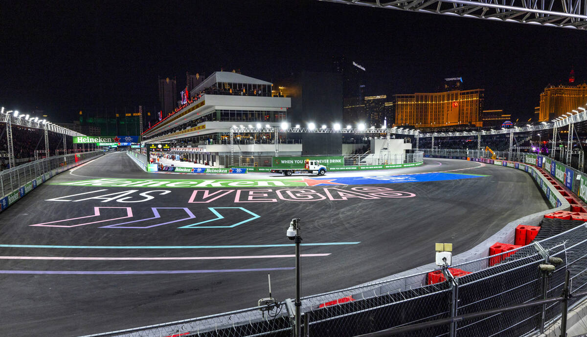 Una grúa sale del edificio de boxes para recoger el coche de Carlos Sainz con Ferrari después ...