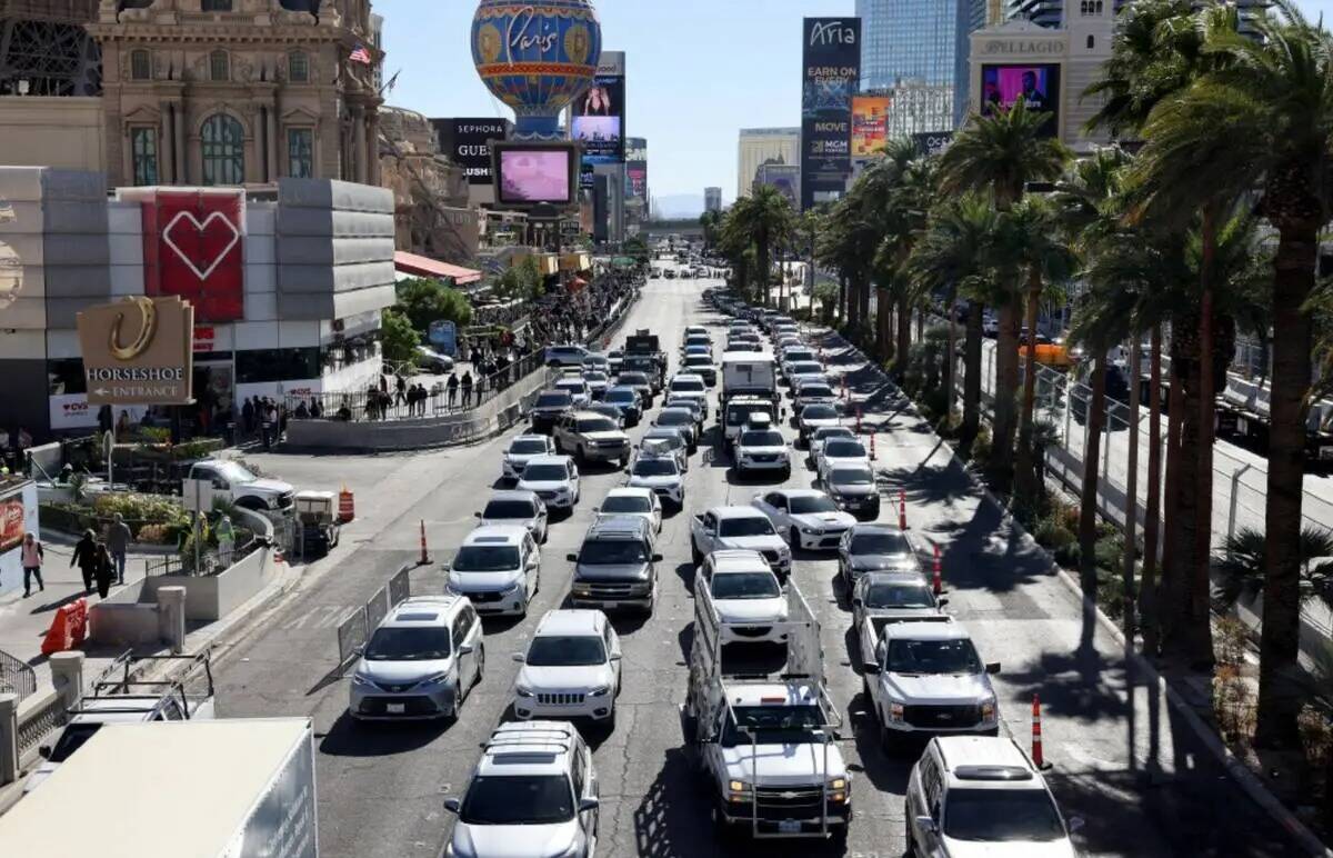 Los autos se abren paso por el Strip cerca de Flamingo Road mientras los equipos retiran las va ...