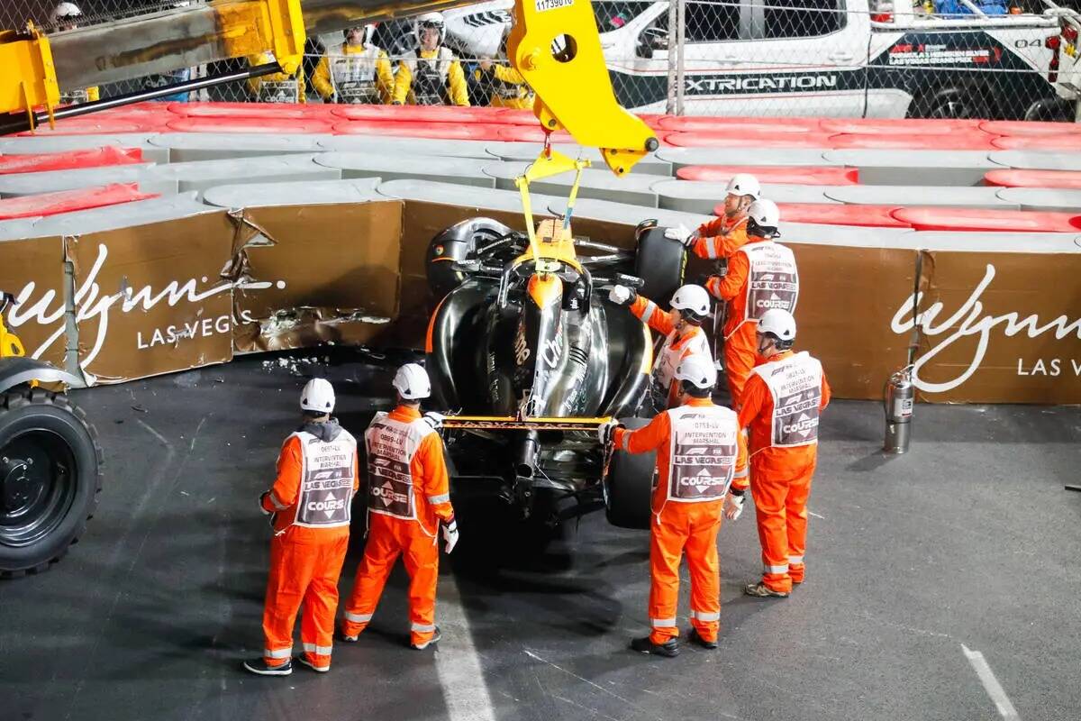 Los equipos voltean el auto del piloto de McLaren, Lando Norris, después de que se estrellara ...