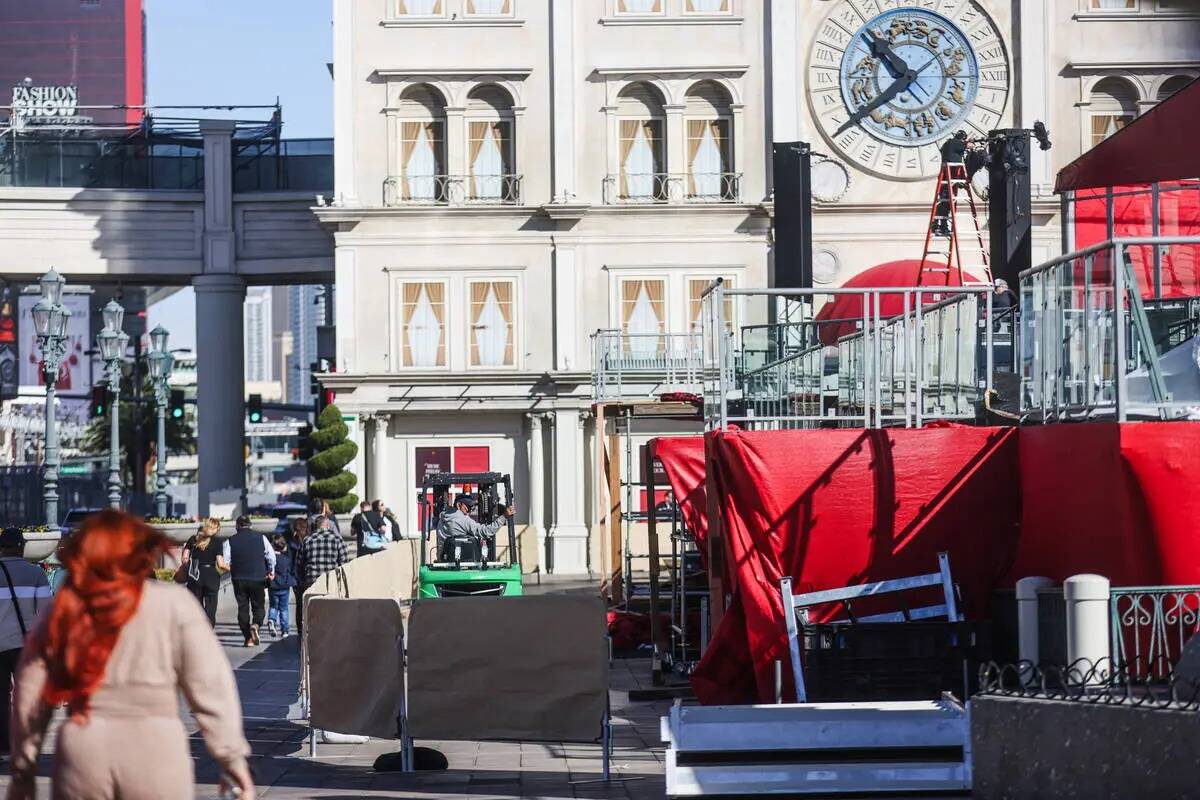 Unos trabajadores desmontan un escenario que servía para entretener a los invitados de la carr ...