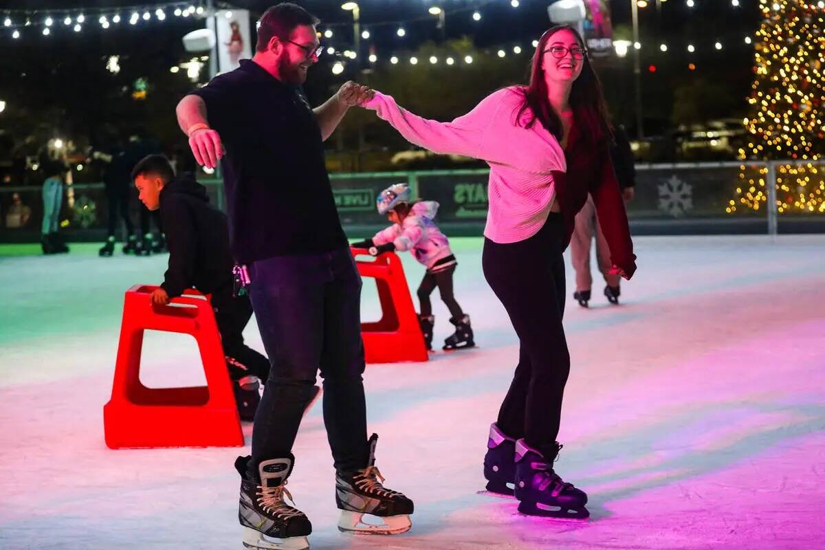 Austin Jacobson patina sobre hielo con su novia Cadence Kapeles en la pista Rock Rink en Downto ...