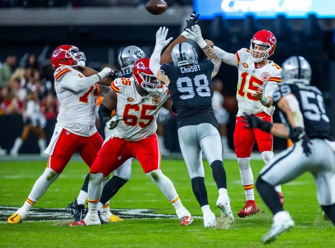 El defensive end de los Raiders Maxx Crosby (98) intenta bloquear un pase del quarterback de lo ...