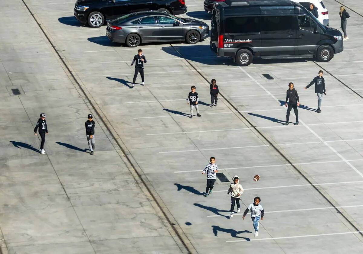 Fanáticos juegan fútbol americano estacionado afuera antes del primer tiempo del partido de l ...