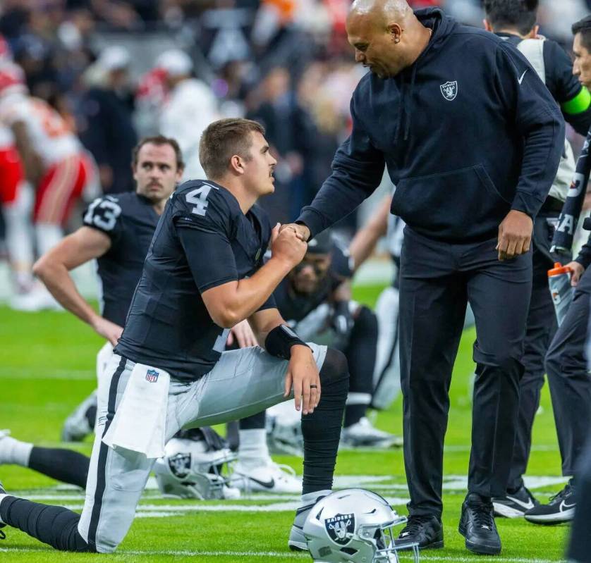 El quarterback de los Raiders Aidan O'Connell (4) estrecha la mano del entrenador jefe interino ...