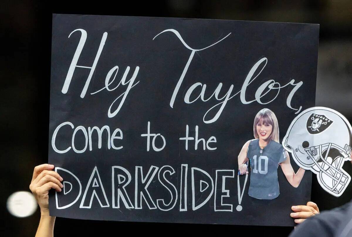 Un fan de los Raiders sostiene un póster de Taylor Swift en la primera mitad de su partido de ...