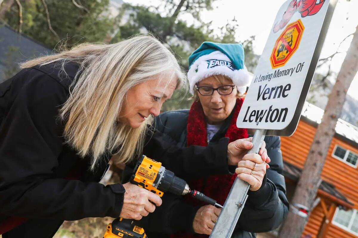 Diane Malone, a la izquierda, y Joan Eddowes ayudan a colocar carteles con los nombres de las v ...