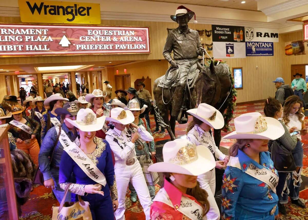 Competidoras del título de Miss Rodeo America pasan por delante de la estatua de Benny Binion, ...